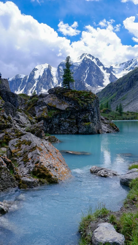 the blue water with snow covered mountains in the background