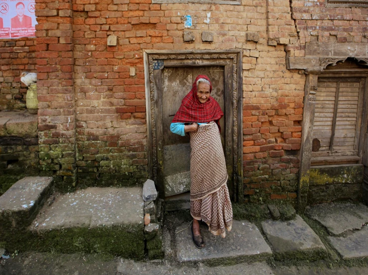 a lady in red scarf leaning on the door