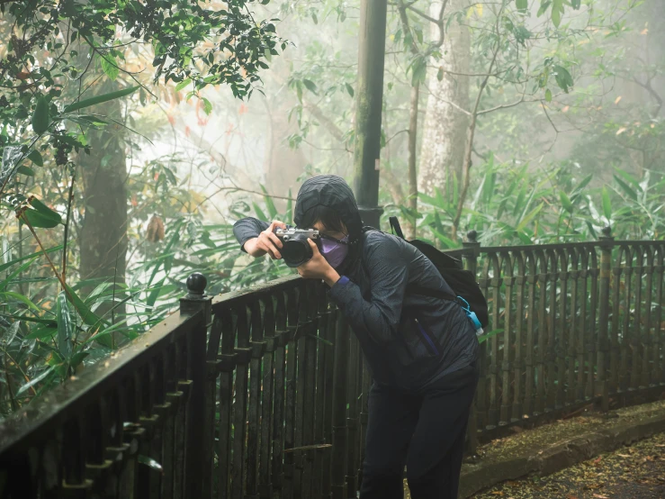 a woman with a backpack takes a picture with her camera