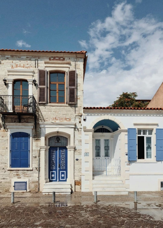 a building with blue shutters and doors and balcony