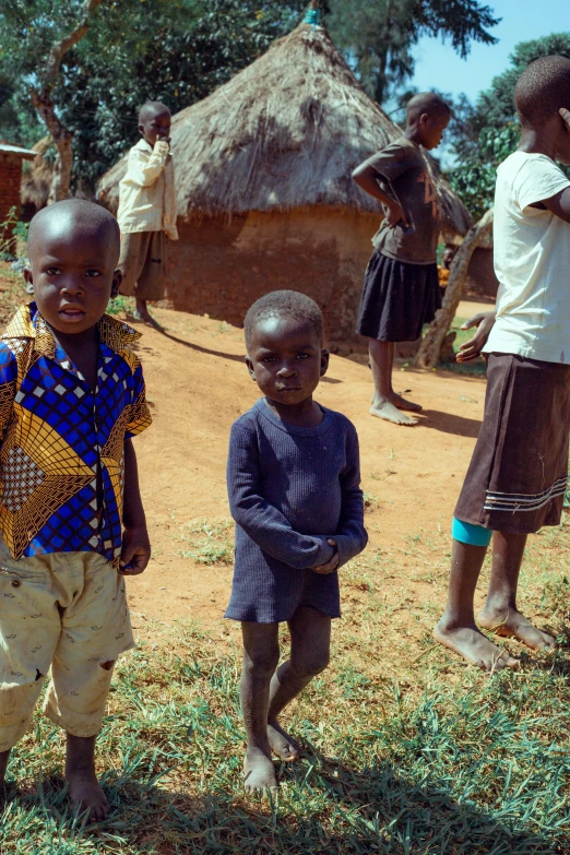 children posing for po in their village with thats roof