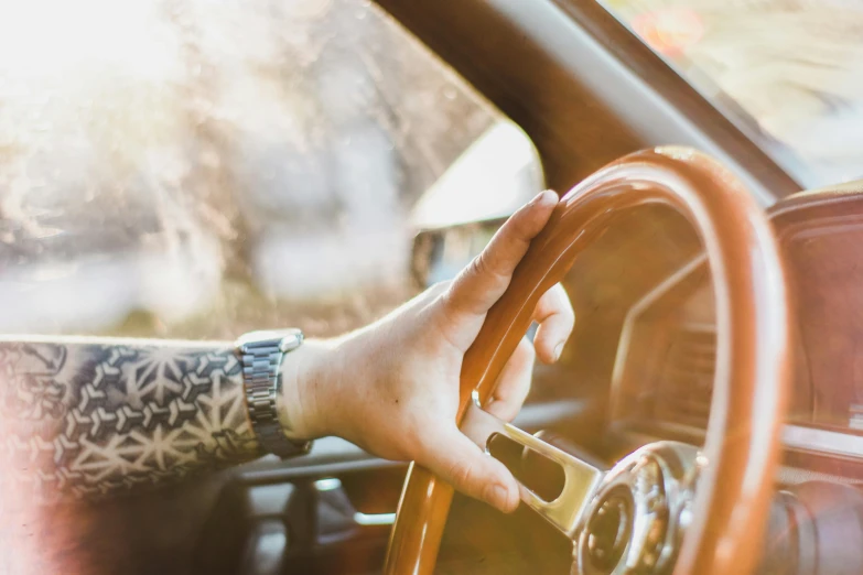 the hand of someone sitting behind a steering wheel