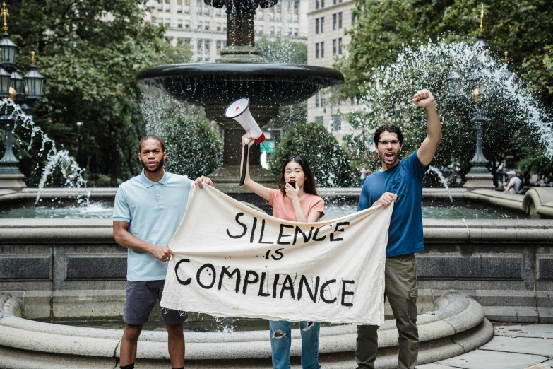 three people posing with a banner that says science is compllane