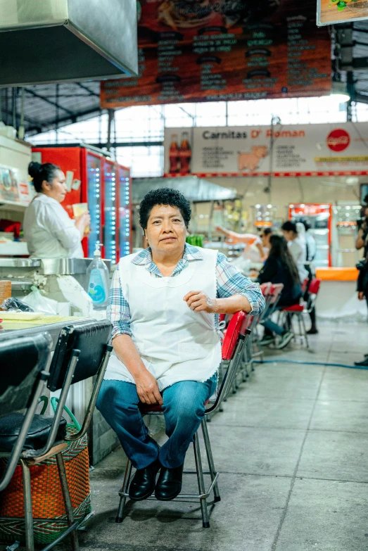 a man sitting in a chair with people looking on