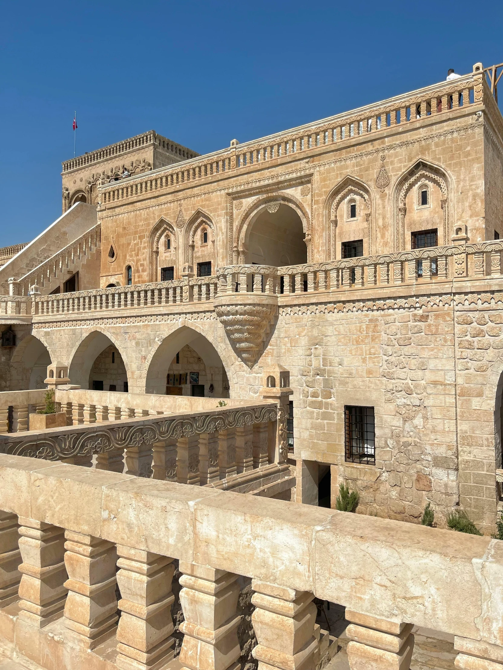 a stone building with arches and columns next to water