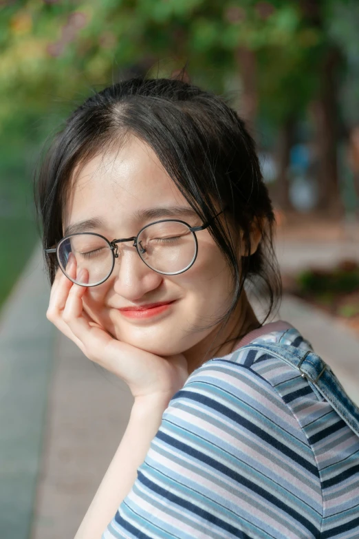 a woman is posing with her hands near her face