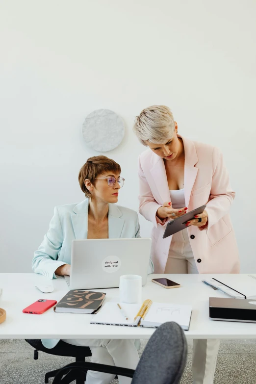 two women in pink jacket working on a laptop