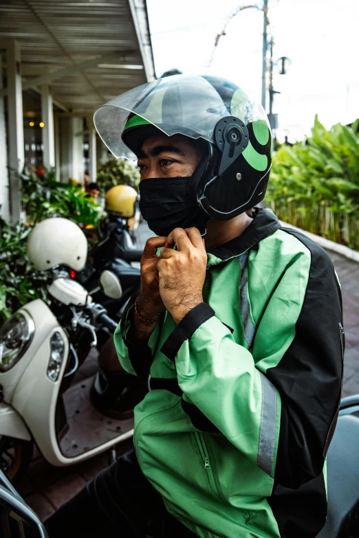 a man in helmet sitting on a moped