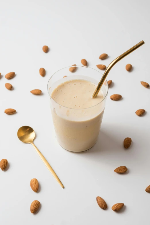 a cup filled with some almonds next to a spoon