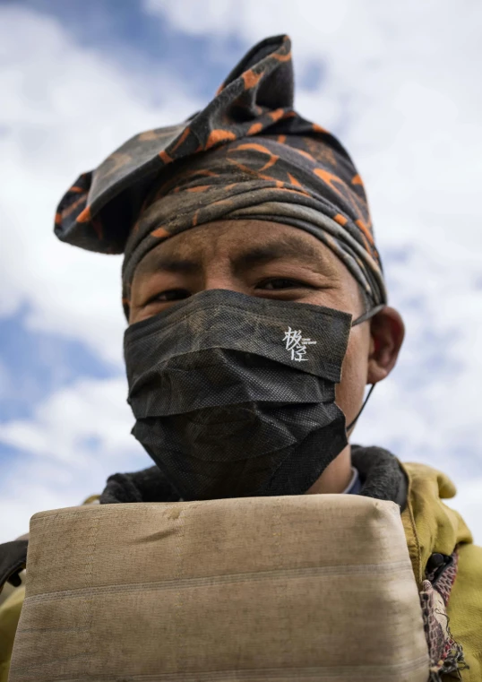 a man with a mask over his face wearing a neck gaiter