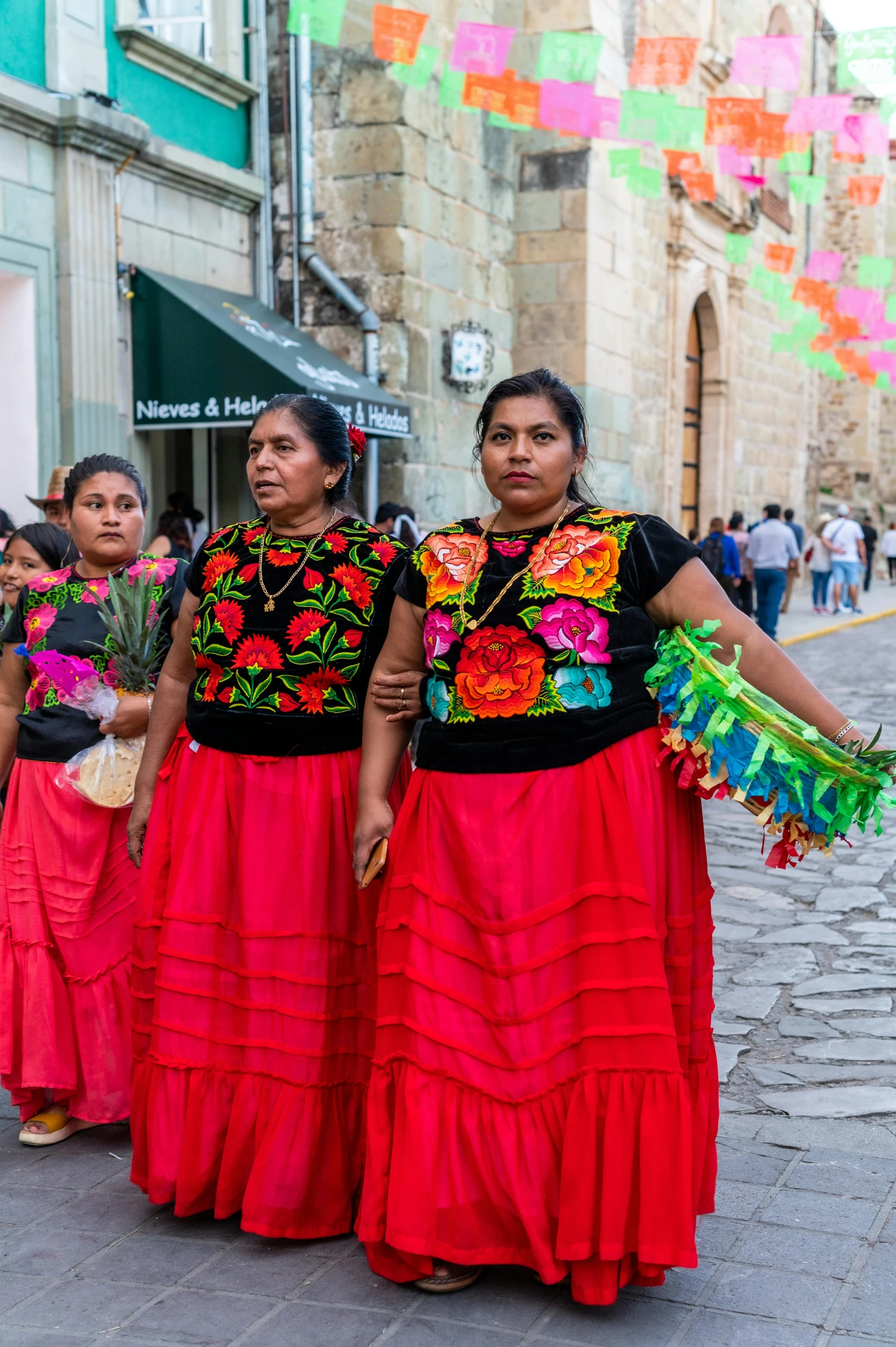 women in traditional costumes standing on the sidewalk