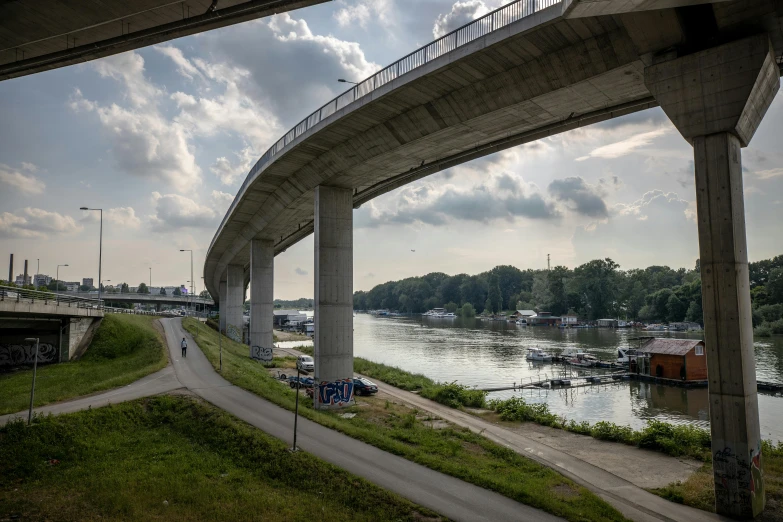 cars travel along a bridge that extends to an waterway