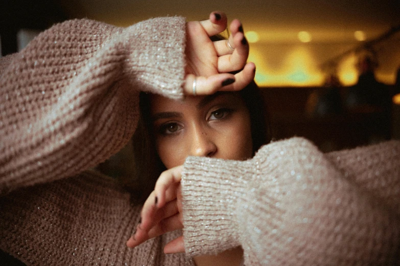 young woman wearing white sweater posing for pograph