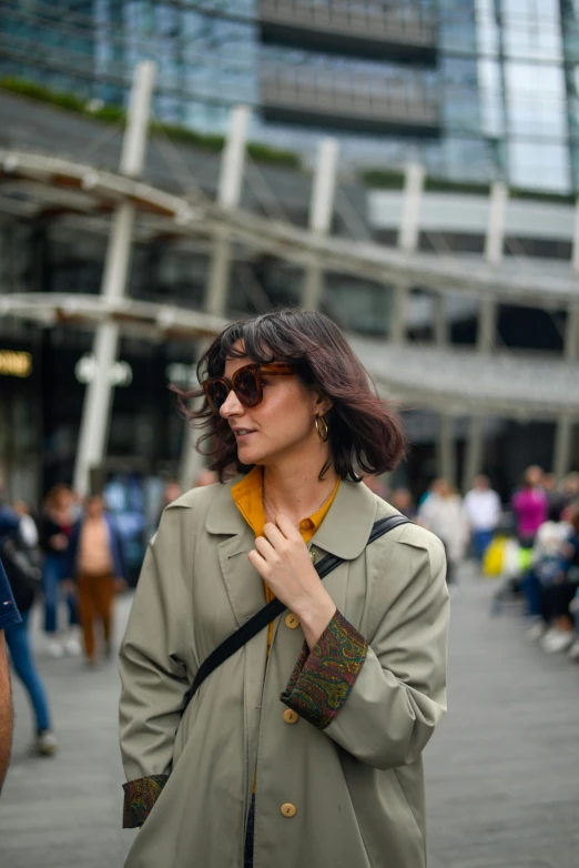 woman with glasses holding her jacket while walking