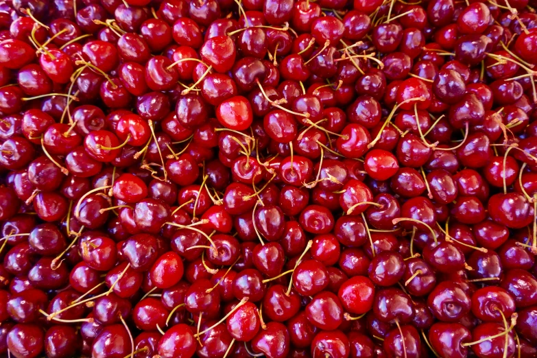 red cherries are piled up in a pile