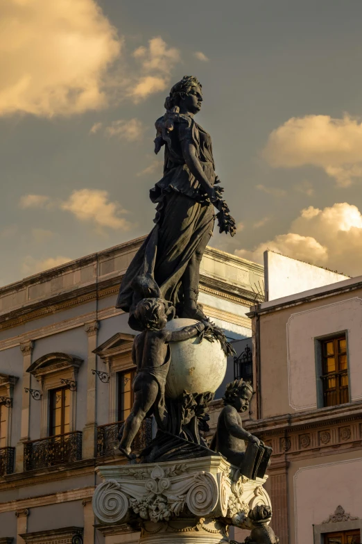 the statue is in front of the building with clock