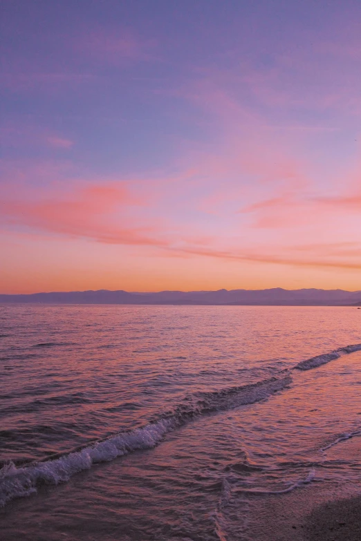 the sun sets as a man stands alone on the beach