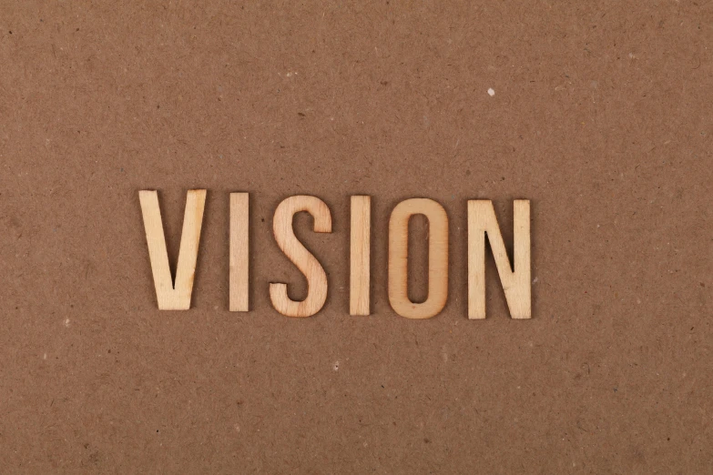 a wooden piece of cut out text spelling a vision