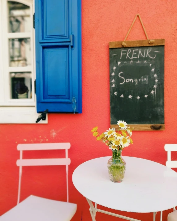 a table and chair are outside with the door open