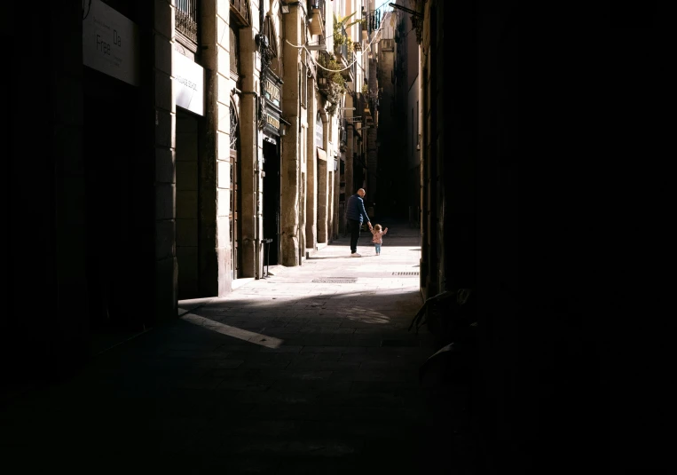 an empty street in the dark with someone walking down it