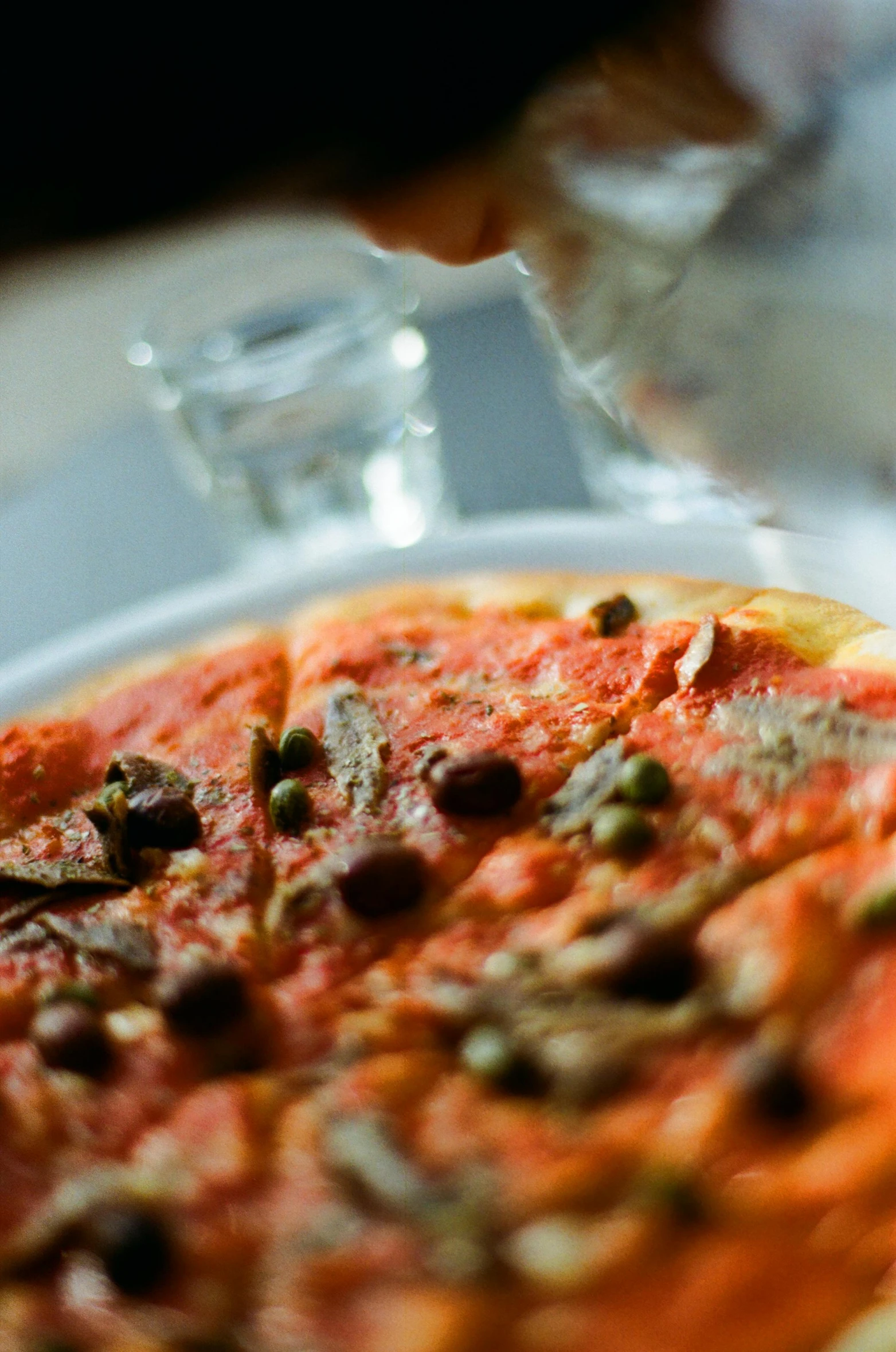 a pizza on a plate with other foods and drinks on the table