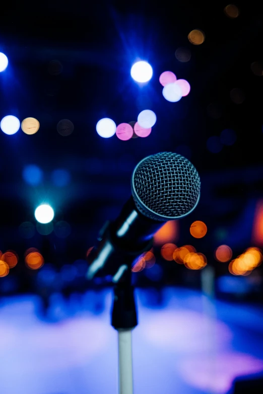 a microphone on stage with blurry lights in the background