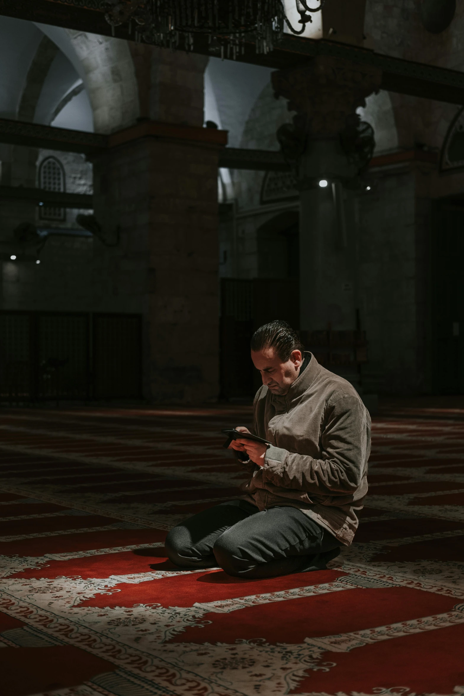 a man on his cell phone inside an islamic prayer room