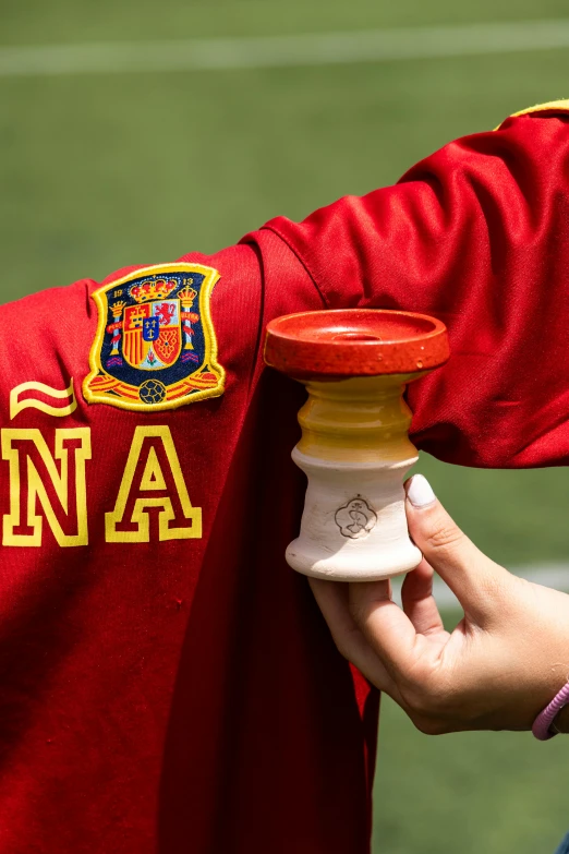 a person in red uniform holding onto the jersey with a coat on it