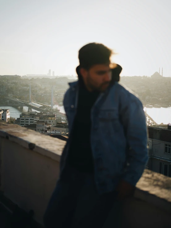 a man in jeans standing on the edge of a ledge