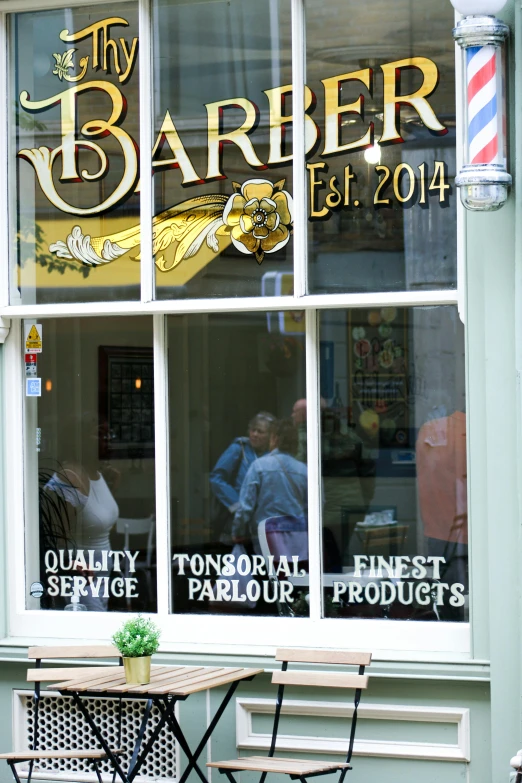 a restaurant window that is holding an advertit for the barber established 2013