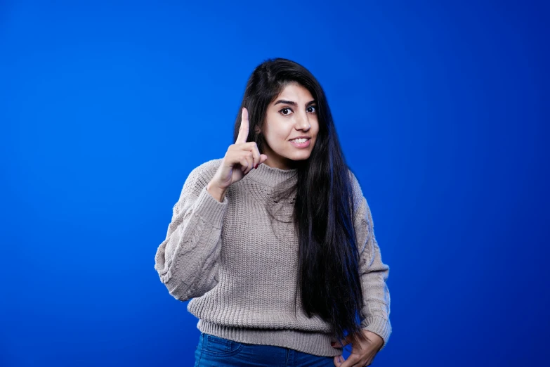 a beautiful woman making a call while standing with her hand on her hip