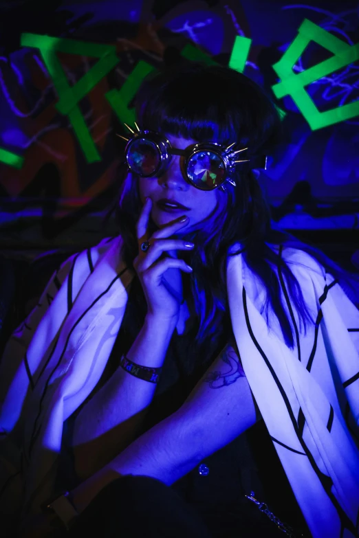 a woman posing in an artistic blue glow holding her hand up to her face