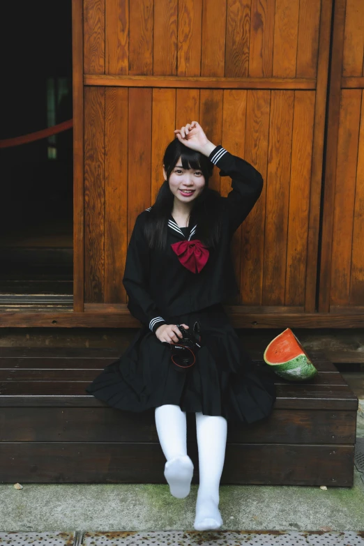 the girl is posing for her picture in a short black dress and knee socks