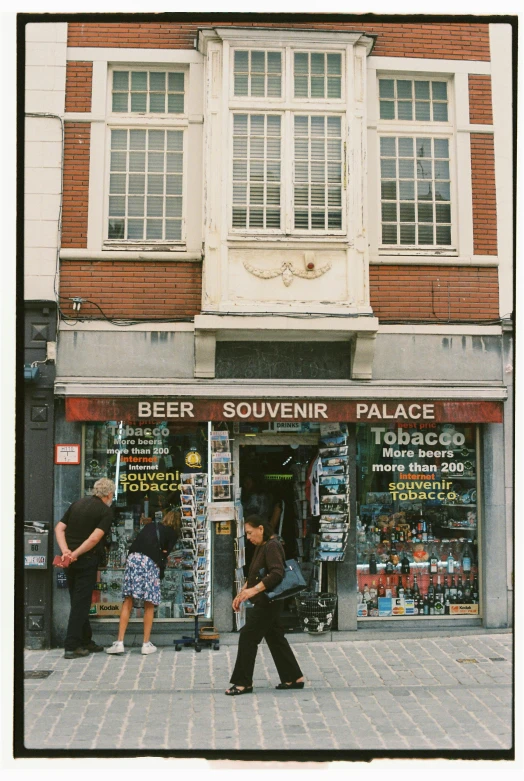 some people are walking around in front of a liquor store