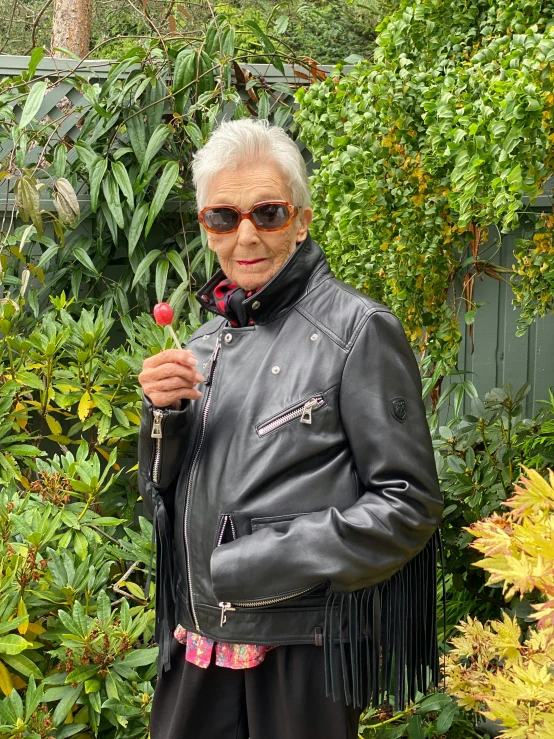 a woman with grey hair holding a red rose