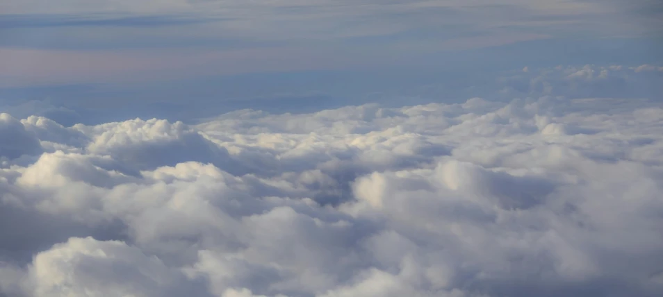 view from an airplane above fluffy clouds in the air