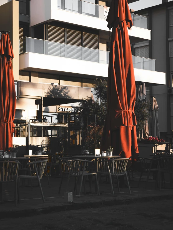 two tables with an orange canopy and several chairs