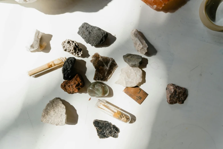 a pile of stones, rocks, and a candle on top of a table