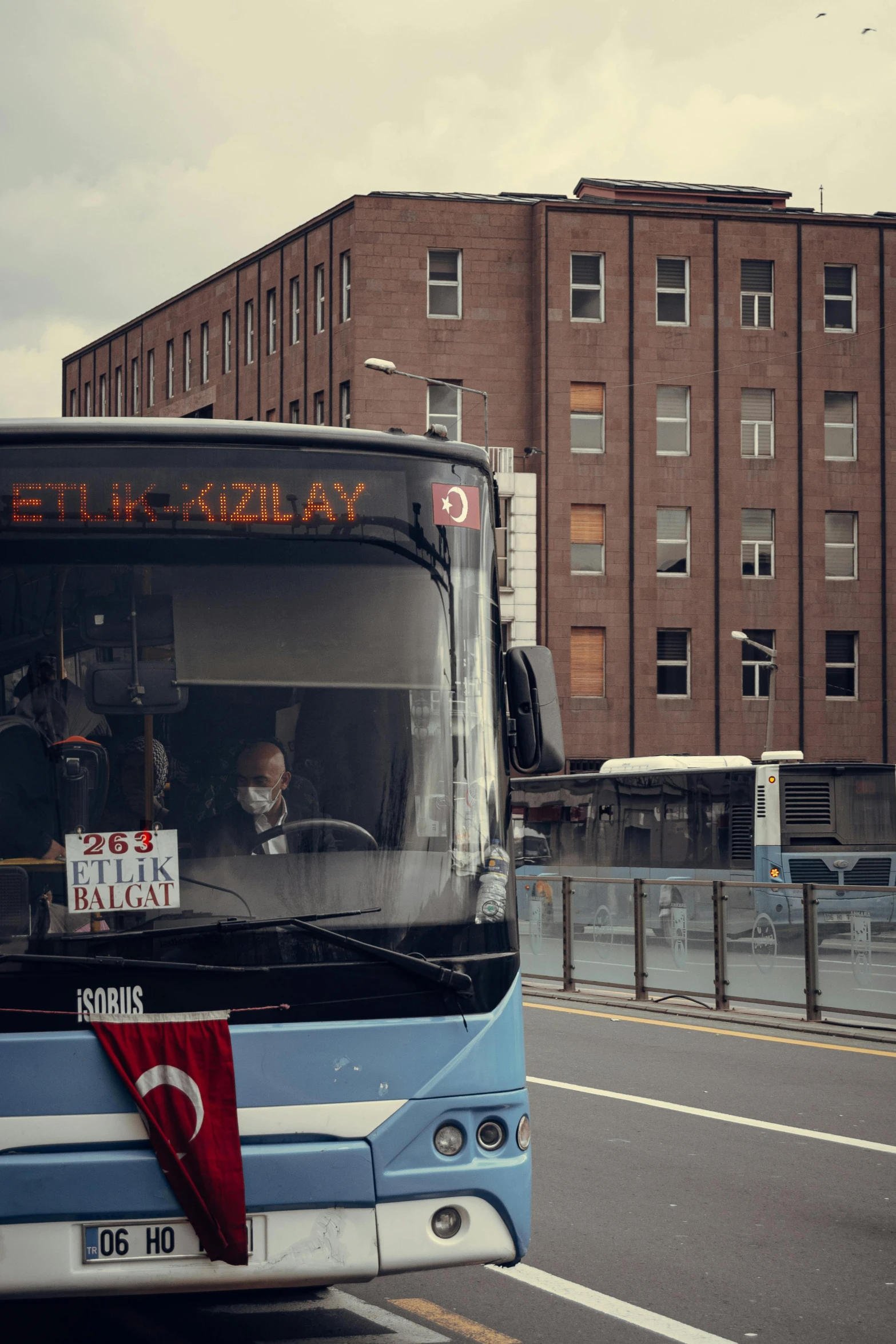 a large bus driving down a street next to tall buildings