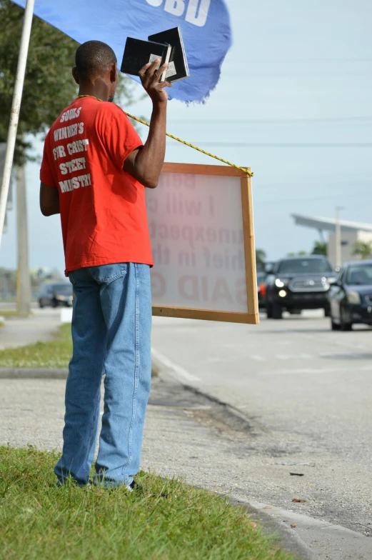 a boy holding a protest sign in front of his face