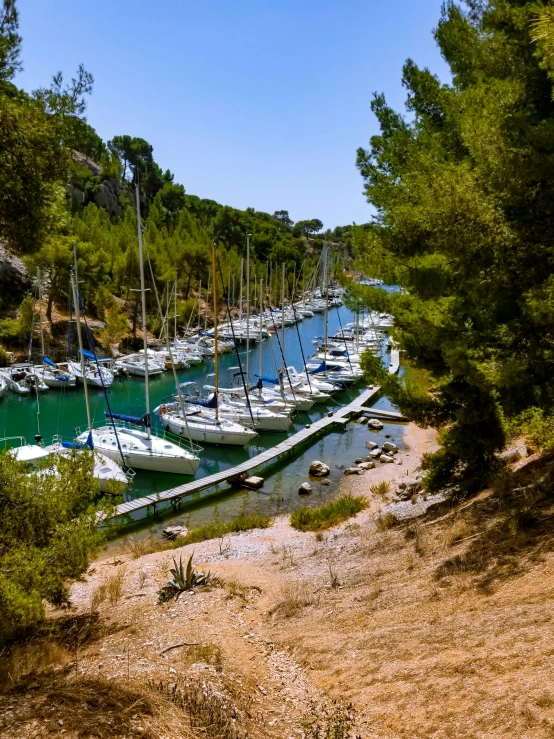 some boats in the water next to a hill