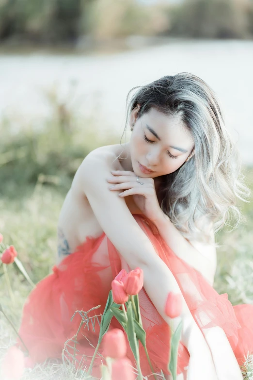 a woman wearing a red dress posing with flowers