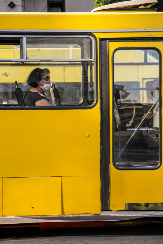 the woman in the bus is wearing a mask