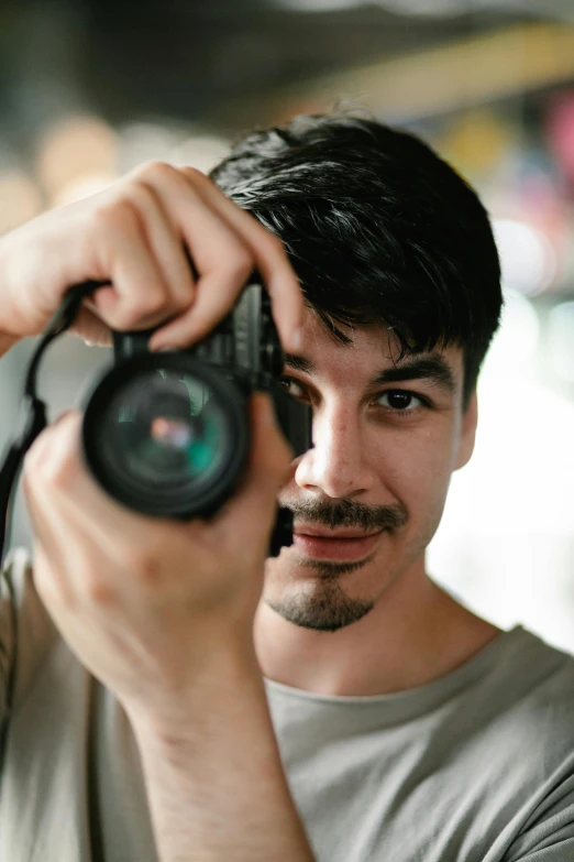 a man takes a pograph of himself holding up his camera