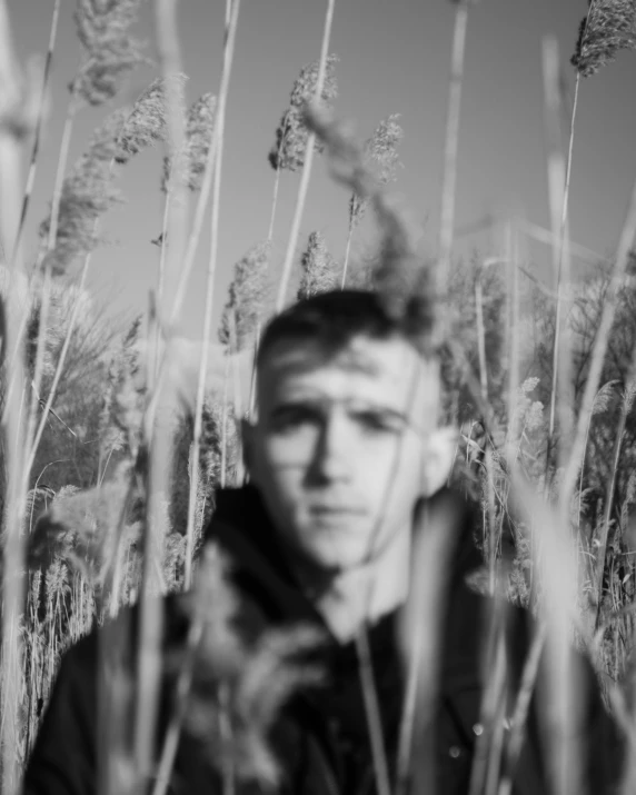 a man is standing in front of tall grass
