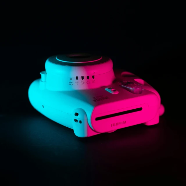 two nintendo wii game controllers glowing in pink and blue