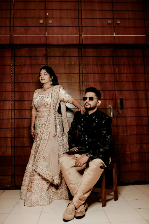 a couple dressed in ethnic dress pose for the camera