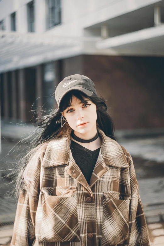 a young woman with long hair in a plaid jacket