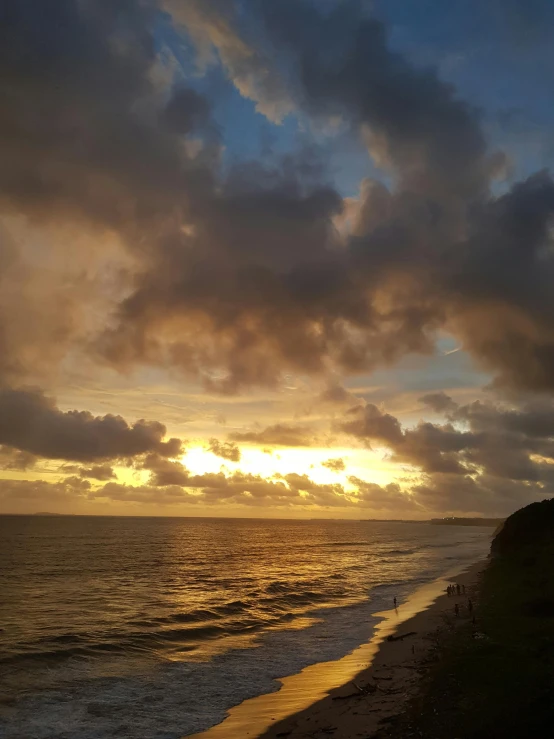 the sun is setting as the ocean waves lap over the shore