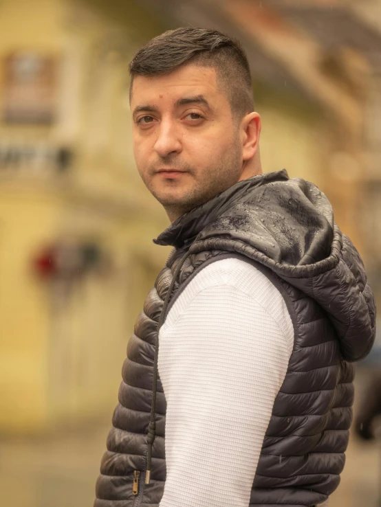 a young man wearing a vest, posing for a po